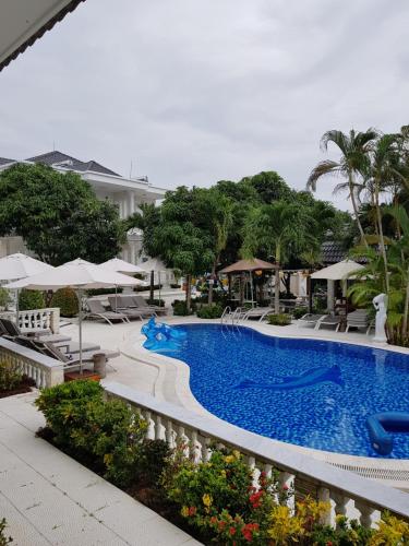 a pool at a resort with chairs and umbrellas at Godiva Villa Phu Quoc in Phu Quoc