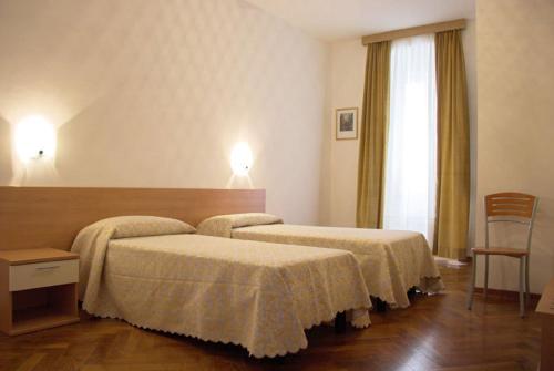 a hotel room with two beds and a window at Pensione Rittmeyer in Trieste