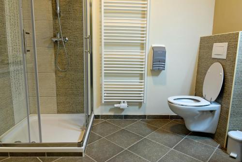 uma casa de banho com um WC e uma cabina de duche em vidro. em Hostel Plus Caffe em Petrovče