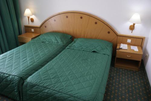 a hotel room with a bed and two night stands at El Mouradi Hammamet in Hammamet