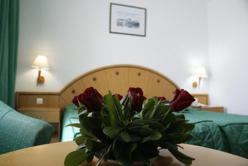 a vase of roses on a table in a hotel room at El Mouradi Hammamet in Hammamet