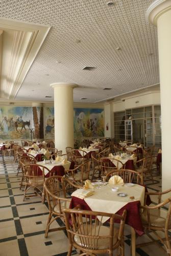 a dining room with tables and chairs in a restaurant at El Mouradi Hammamet in Hammamet