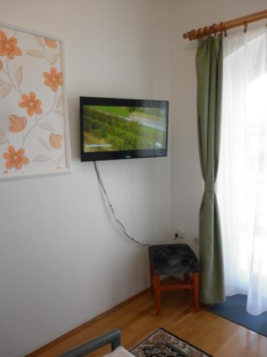a flat screen tv hanging on a wall next to a window at Manor Villa in Hévíz