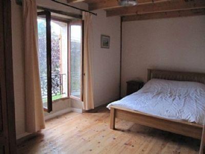 a bedroom with a bed and a large window at Le Petite Grange Gite in Sos