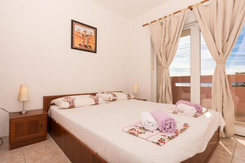 a bedroom with a bed with towels on it at Apartment Pavic-Nikic in Trogir