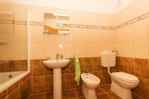 a bathroom with a sink and a toilet and a tub at Apartment Pavic-Nikic in Trogir