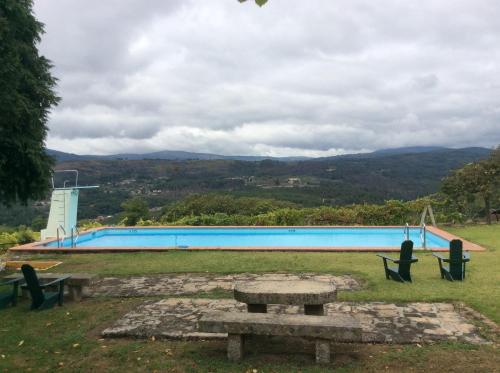 a picnic table in front of a swimming pool at Quinta da Calçada in Melgaço