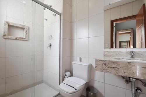 a bathroom with a toilet and a shower and a sink at Hotel Caminhos da Serra in Três Coroas