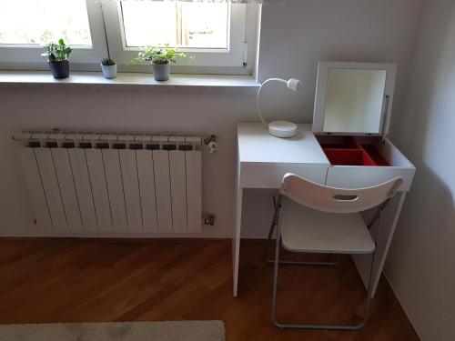 a white desk with a mirror and a chair at Apartment 40 in Zagreb
