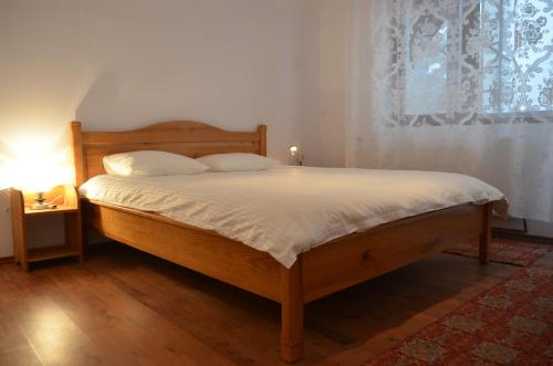 Schlafzimmer mit einem Holzbett mit weißer Bettwäsche in der Unterkunft Casa Hai la Ranca in Ranca