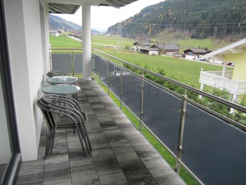 a balcony with a table and chairs and a field at Appartementhaus Gretzel in Wagrain