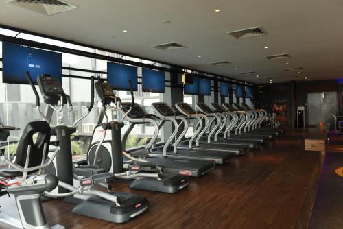 a gym with a row of treadmills and ellipticals at Vangohh Eminent Hotel & Spa in Bukit Mertajam