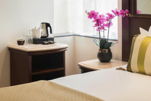 a bedroom with a vase with flowers on a table at The George Street Hotel in Oxford