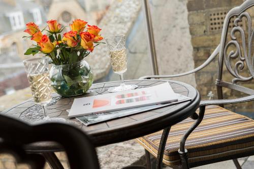 a table with a vase of flowers and a laptop on it at The George Street Hotel in Oxford