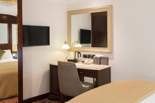 a hotel room with a desk and a mirror at The George Street Hotel in Oxford