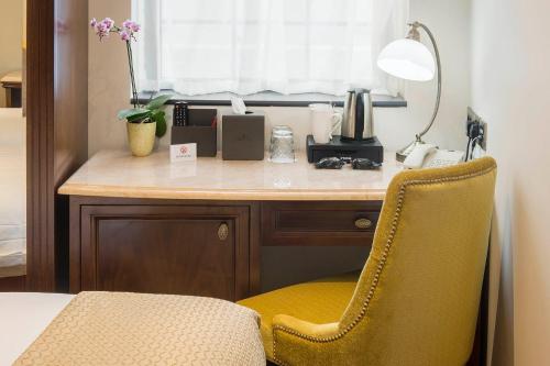 a desk with a yellow chair in a room at The George Street Hotel in Oxford