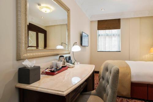 a hotel room with a bed and a mirror at The George Street Hotel in Oxford