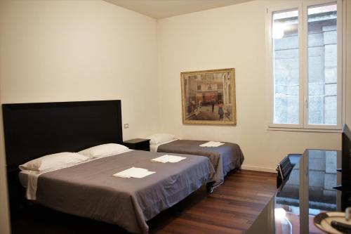1 dormitorio con 2 camas y un cuadro en la pared en B&B Parigi, en Bolonia