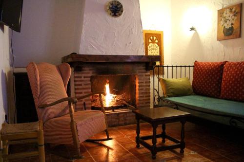 a living room with a fireplace and a couch at Casas Rurales el Palomar in Ossa de Montiel