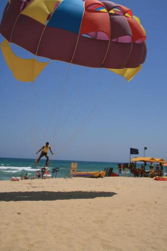 a person flying a large kite on the beach at El Mouradi Hammamet in Hammamet