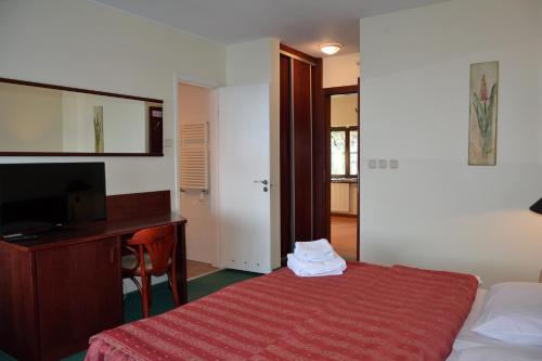 a bedroom with a desk and a bed with a red blanket at Willa Victor in Jastrzębia Góra