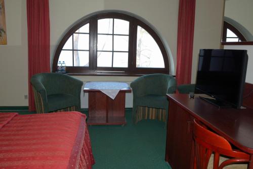 a room with a bed and a table with chairs at Willa Victor in Jastrzębia Góra