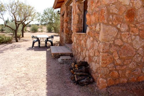 a table and bench next to a stone building at Casas Rurales el Palomar in Ossa de Montiel