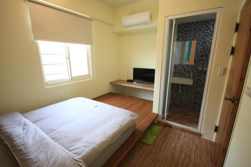 a small room with a bed and a television at Coffee Tree in Lugang