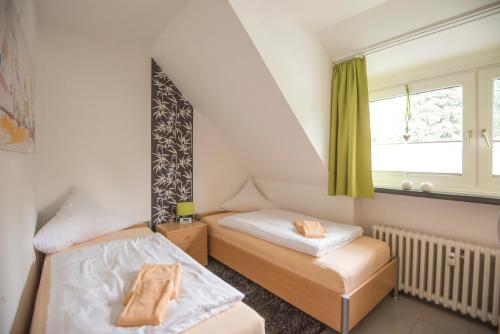 two beds in a small room with a window at Wietheger´s Gästehaus Centrum in Willingen