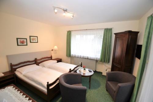 a bedroom with a bed and two chairs and a table at Hotel Central in Bad Sooden-Allendorf