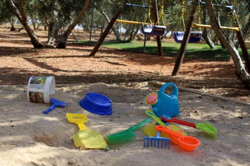 a sandbox with toys in the sand in a park at Casas Rurales el Palomar in Ossa de Montiel
