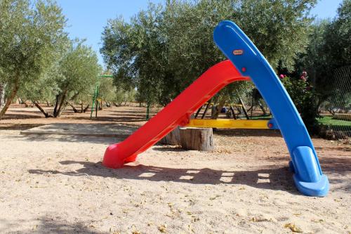 um escorrega azul e vermelho num parque em Casas Rurales el Palomar em Ossa de Montiel
