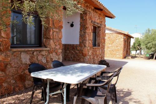 a table and chairs in front of a stone building at Casas Rurales el Palomar in Ossa de Montiel