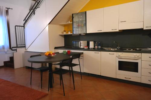 a kitchen with white cabinets and a table with chairs at La Loggia Vicenza in Vicenza