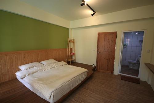 a bedroom with a bed and a ladder and a bathroom at Coffee Tree in Lugang