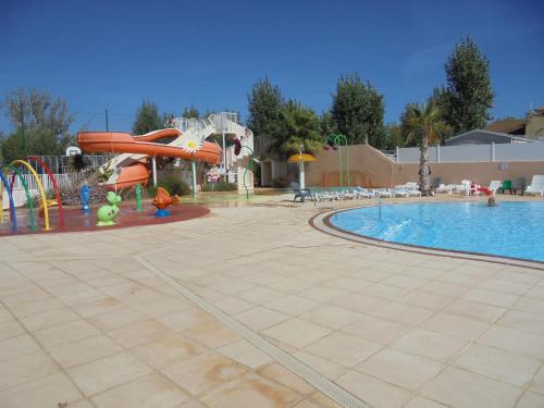 une piscine avec un parc aquatique avec un toboggan aquatique dans l'établissement Mobilhome Sables du midi, à Valras-Plage