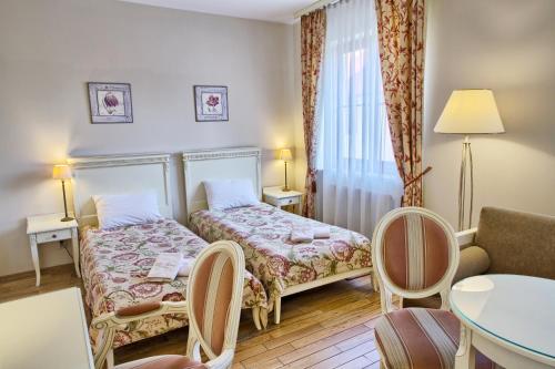 Habitación de hotel con cama, mesa y sillas en Villa Estera - Hotel & Restauracja, en Michałowice