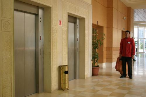 a man walking down a hallway in a building at El Mouradi Hammamet in Hammamet