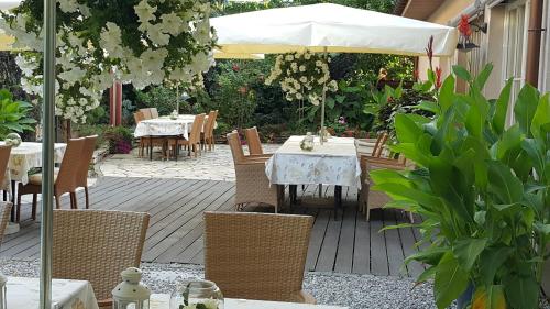 a patio with a table and chairs and an umbrella at Villa Estera - Hotel & Restauracja in Michałowice