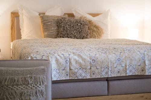 a bed with a comforter and a chair in a bedroom at Die Fruchtstub in Meckenheim
