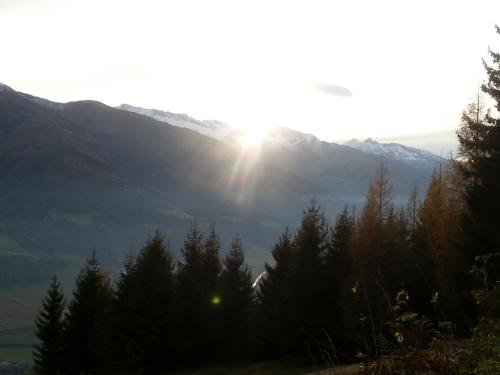 a view of a mountain with trees and the sun at Apartment Lochner Piesendorf-Walchen in Piesendorf