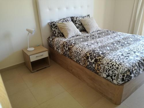 ラゴスにあるT1Encosta da Marina-Lagosのベッドルーム1室(ベッド1台、ナイトスタンド、ランプ付)