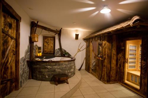 a bathroom with a tub in a room with wooden walls at RANČ JUREŠ in Ljutomer
