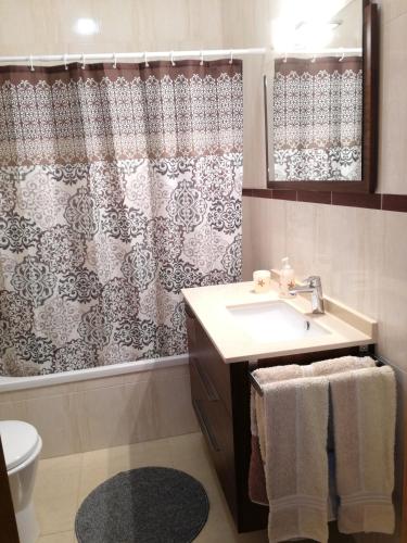 a bathroom with a sink and a shower curtain at T1Encosta da Marina-Lagos in Lagos