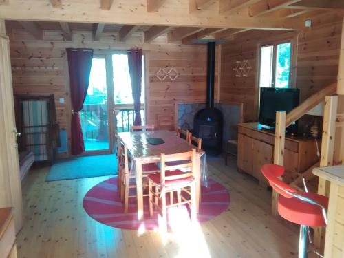 a dining room with a table and a stove at Chalet bois au milieu des Pyrénées in Soldeu lʼHospitalet