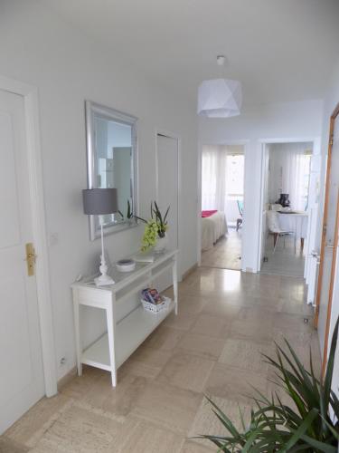 Cette chambre blanche dispose d'une table et d'un miroir. dans l'établissement Escape to the French Riviera, à Villefranche-sur-Mer
