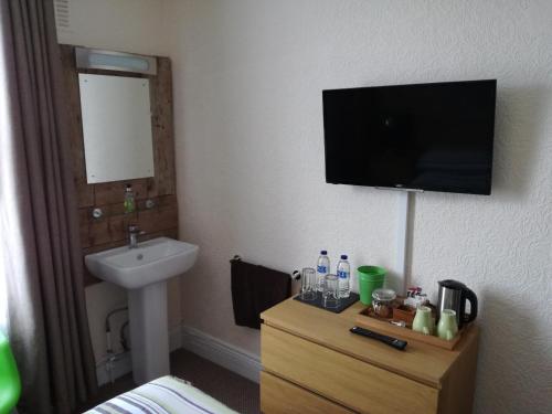 ウェイマスにあるDriftwood B&B Weymouthのバスルーム(洗面台付)、壁掛けテレビが備わります。