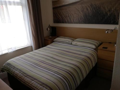 a large bed in a bedroom with a window at Driftwood B&B Weymouth in Weymouth