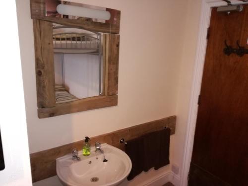 a bathroom with a sink and a mirror at Driftwood B&B Weymouth in Weymouth