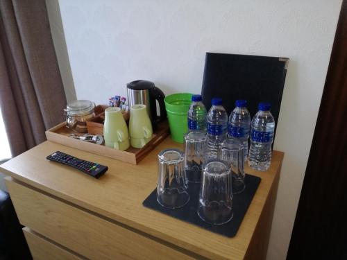 a table with a bunch of bottles and glasses on it at Driftwood B&B Weymouth in Weymouth